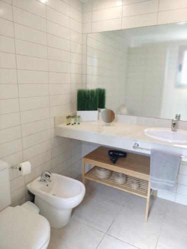 a white bathroom with a toilet and a sink at Villa Lía by SunHousesCanarias with heated pool in Salobre
