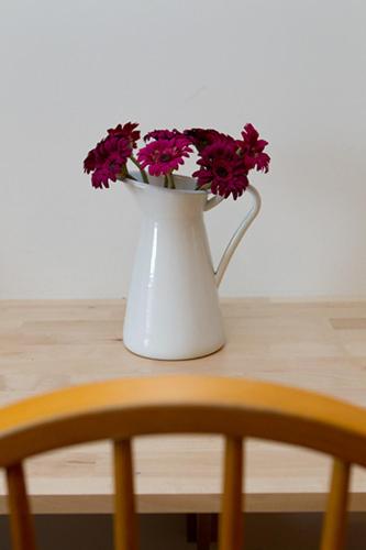 a white vase with flowers in it on a table at Glencourt Apartments in Dublin