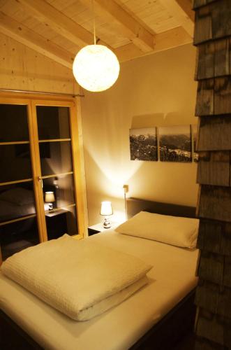 a bedroom with two beds and a large window at Hüttenhotel Husky Lodge in Muotathal
