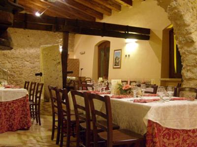 a dining room with tables and chairs in a building at Corte dei Monaci in Canicattì