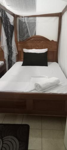 a bed with two white towels on top of it at Lyneks Cosy Apartment in Mombasa
