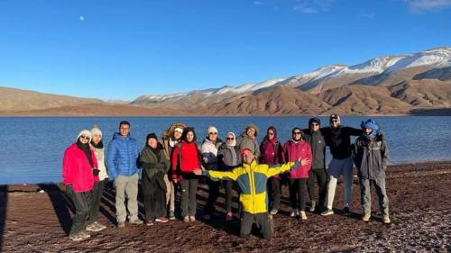 a group of people standing in front of a body of water at Maison D'hôtes Chez Bassou Agoudal in Agoudal