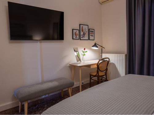 a bedroom with a bed and a desk with a television at Nima's house, traditional flat with lake view in Aitolikón
