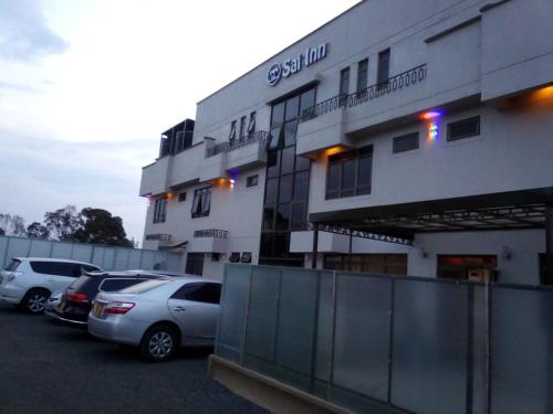 a building with cars parked in a parking lot at Sai Inn Eldoret in Eldoret