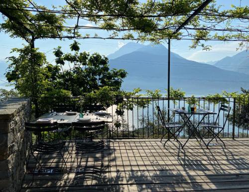 a table and chairs on a patio with a view of the ocean at Agriturismo Treterre in Pianello Del Lario
