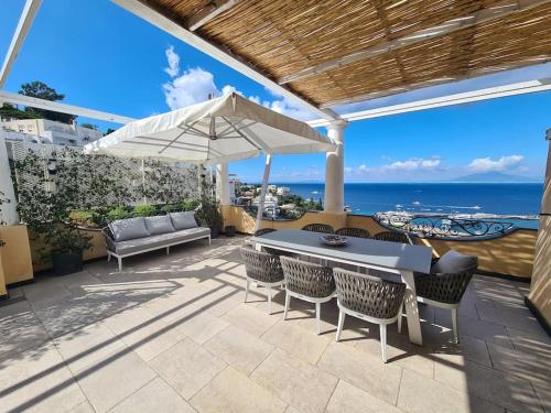 a patio with a table and chairs and an umbrella at La Spiga in Capri