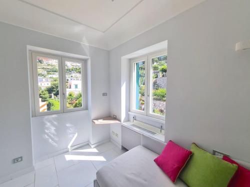 Habitación blanca con 2 ventanas y sofá en La Spiga, en Capri