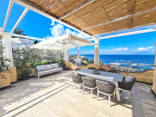 a patio with a table and chairs and an umbrella at La Spiga in Capri