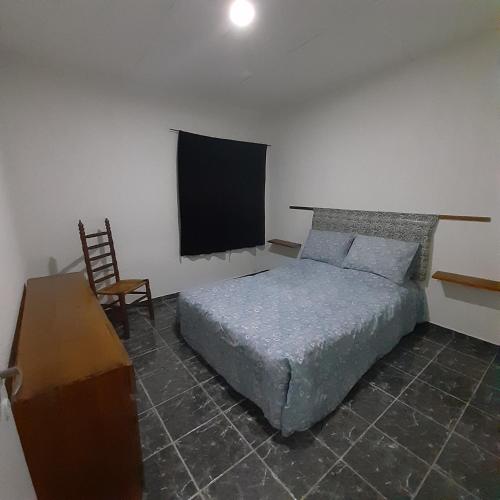 1 dormitorio con 1 cama, TV y silla en Alojamiento en Mendoza en Godoy Cruz