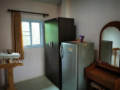 uma cozinha com um frigorífico e uma janela em ชมจันทร์รีสอร์ท ไชยา Chomjan resort 