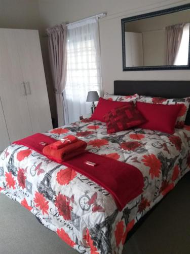 a bedroom with a bed with a red and white blanket at Prince Alfreds in Caledon