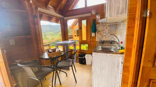 uma cozinha com mesa e cadeiras numa pequena casa em Villa Angela Glamping & Tiny Houses em Paipa