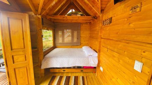 a bedroom in a log cabin with a bed in it at Villa Angela Glamping & Tiny Houses in Paipa