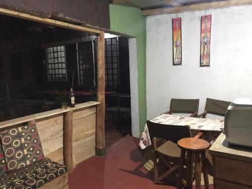a dining room with a table and chairs and a television at Sonofjohnhomestay in Karatu
