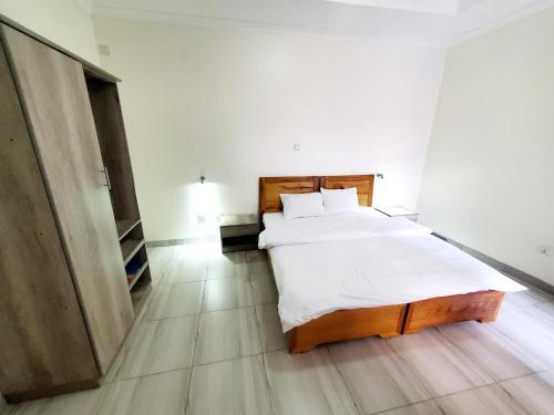 a bedroom with a large bed with white sheets at Ebenezer Hotel Apartments in Kigali