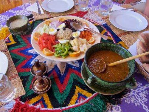 un tavolo con un piatto di cibo e una ciotola di zuppa di Dar Sidi Bounou a M'Hamid