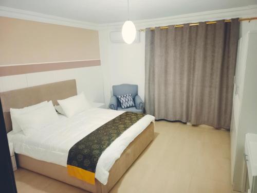 a bedroom with a bed and a blue chair at Pomegranate Tree in Wadi Musa