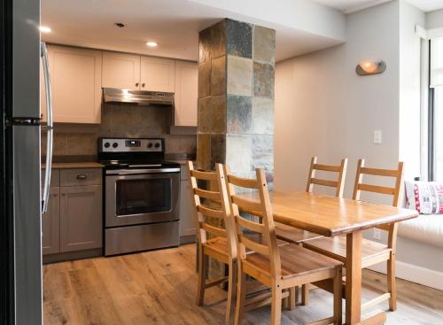 a kitchen with a wooden dining room table and chairs at Gibbons Life Accommodations in Whistler