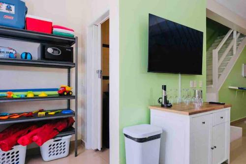 a room with a desk and a tv on a wall at Eagle Beach Aruba Breeze Condominium Lime in Palm-Eagle Beach