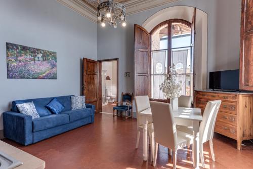 a living room with a blue couch and a table at Appartamenti Villa Mascagni in Volterra