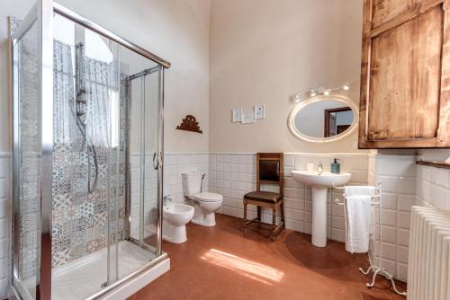 a bathroom with two toilets and a shower and a sink at Appartamenti Villa Mascagni in Volterra