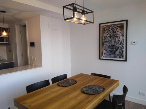 ein Esstisch mit Stühlen und einem Bild an der Wand in der Unterkunft 304 San Lorenzo in Mar del Plata