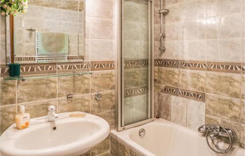 La salle de bains est pourvue d'une baignoire, d'un lavabo et d'une douche. dans l'établissement Beautiful Home In Szczedrzyk With 3 Bedrooms, Sauna And Wifi, à Szczedrzyk