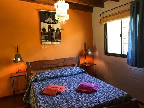 Un dormitorio con una cama con dos bolsas. en Toca Madera en Merlo