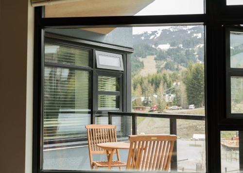 two chairs and a table in front of a window at Gibbons Life Accommodations in Whistler