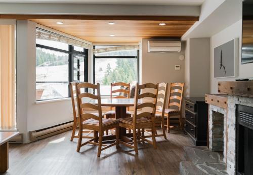 a dining room with a table and chairs and a fireplace at Gibbons Life Accommodations in Whistler