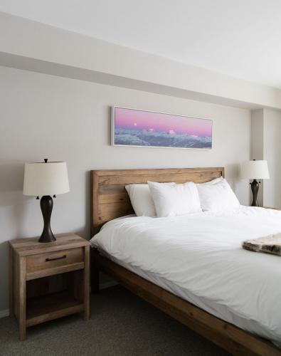 a bedroom with a large bed with a wooden headboard at Gibbons Life Accommodations in Whistler