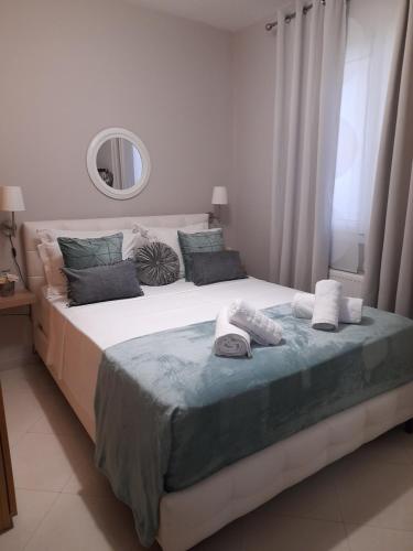 sypialnia z dużym łóżkiem z ręcznikami w obiekcie Luxury & Cozy Apartment w mieście Wolos