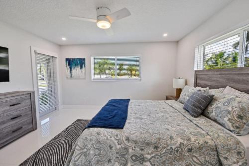 a bedroom with a bed and a ceiling fan at Ariel Beach Cottage in Pompano Beach
