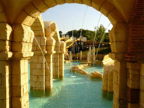 un toboggan dans un parc à thème avec de l'eau bleue dans l'établissement Casita Néracaise, à Nérac