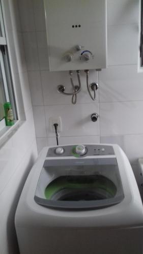 uma máquina de lavar roupa na casa de banho com um lavatório em Sobrado Oktober com Piscina em Santa Cruz do Sul
