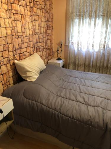a bedroom with a bed and a brick wall at King & Queen in Buenos Aires