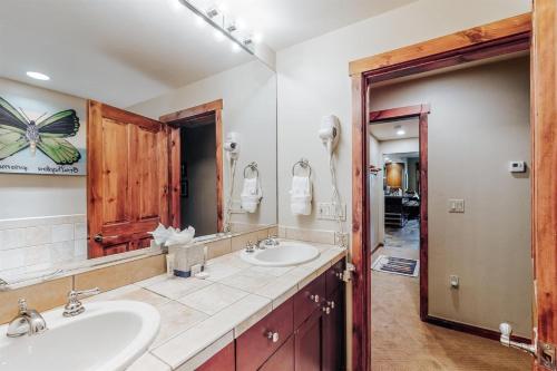baño con 2 lavabos y espejo grande en Perfectly Placed 2 Bedroom Vacation Rental In Historic Downtown Breckenridge With Access To Hot Tub And Pool, en Breckenridge