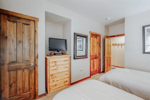 a bedroom with a bed and a tv on a dresser at Perfectly Placed 2 Bedroom Vacation Rental In Historic Downtown Breckenridge With Access To Hot Tub And Pool in Breckenridge