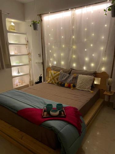 a bedroom with a large bed with lights on the wall at Casa - By Great Impressions in Pune