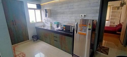 eine Küche mit einem Kühlschrank und einer Arbeitsplatte in der Unterkunft Casa - By Great Impressions in Pune