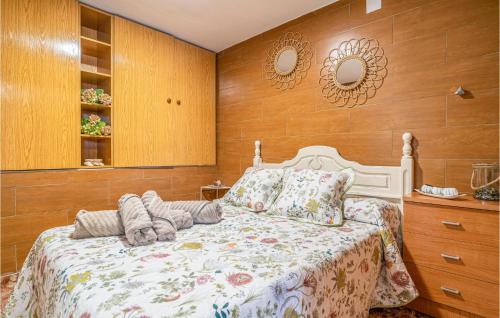 1 Bedroom Lovely Home In Jubrique في Jubrique: غرفة نوم بسرير وجدران خشبية