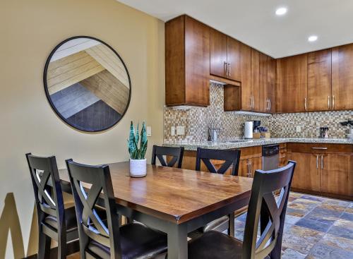 uma cozinha com uma mesa de madeira e cadeiras em Luxurious Condo with Spa, Steam Room hosted by Fenwick Vacation Rentals em Canmore