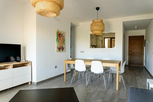 a dining room with a table and white chairs at Modern apartment in residential complex with pools in Costa de Antigua