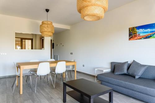 a living room with a couch and a table at Modern apartment in residential complex with pools in Costa de Antigua