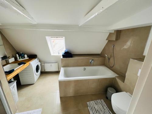een kleine badkamer met een bad en een wasmachine bij See Igel Sjöborre in Wismar