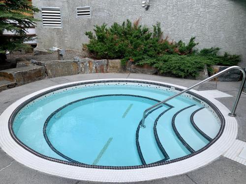 a large swimming pool with a metal rail around it at Luxurious Condo with Spa, Steam Room hosted by Fenwick Vacation Rentals in Canmore