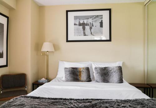 a bedroom with a white bed with two pillows at Gibbons Life Accommodations in Whistler