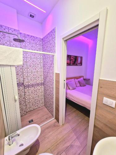 a purple room with a bed and a sink at Sublime in Bari