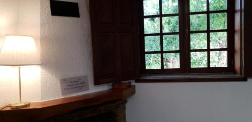 a lamp sitting next to a window in a room at Quinta de Carvalhal - Casa de Campo in Guimarães
