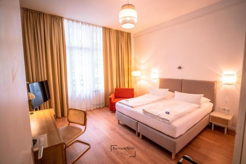 a hotel room with a bed and a chair at Boutique Hotel Kerlin in Berlin